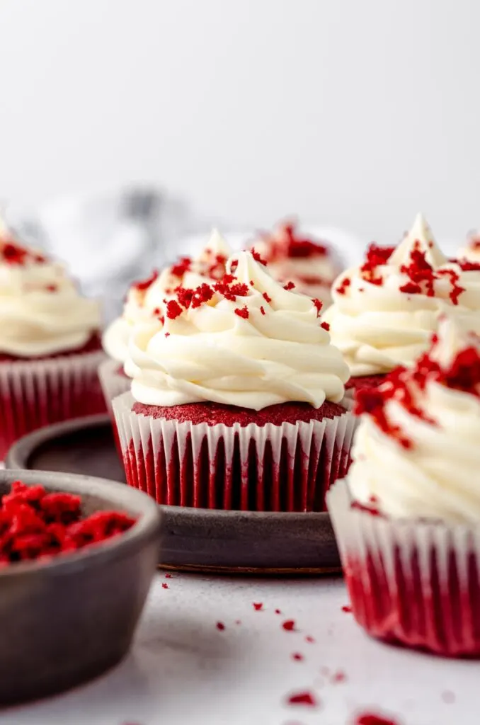 red velvet cupcakes with cream cheese frosting and red velvet crumb topping.