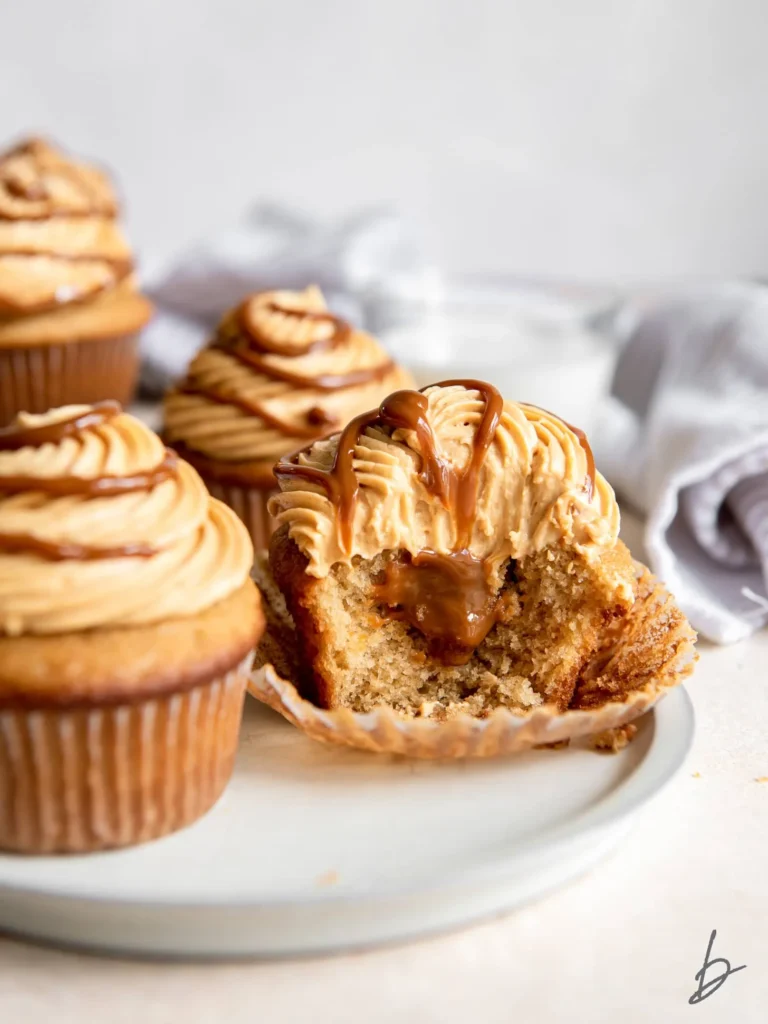 dulce de leche cupcakes cut in half showing dulce de leche filling.