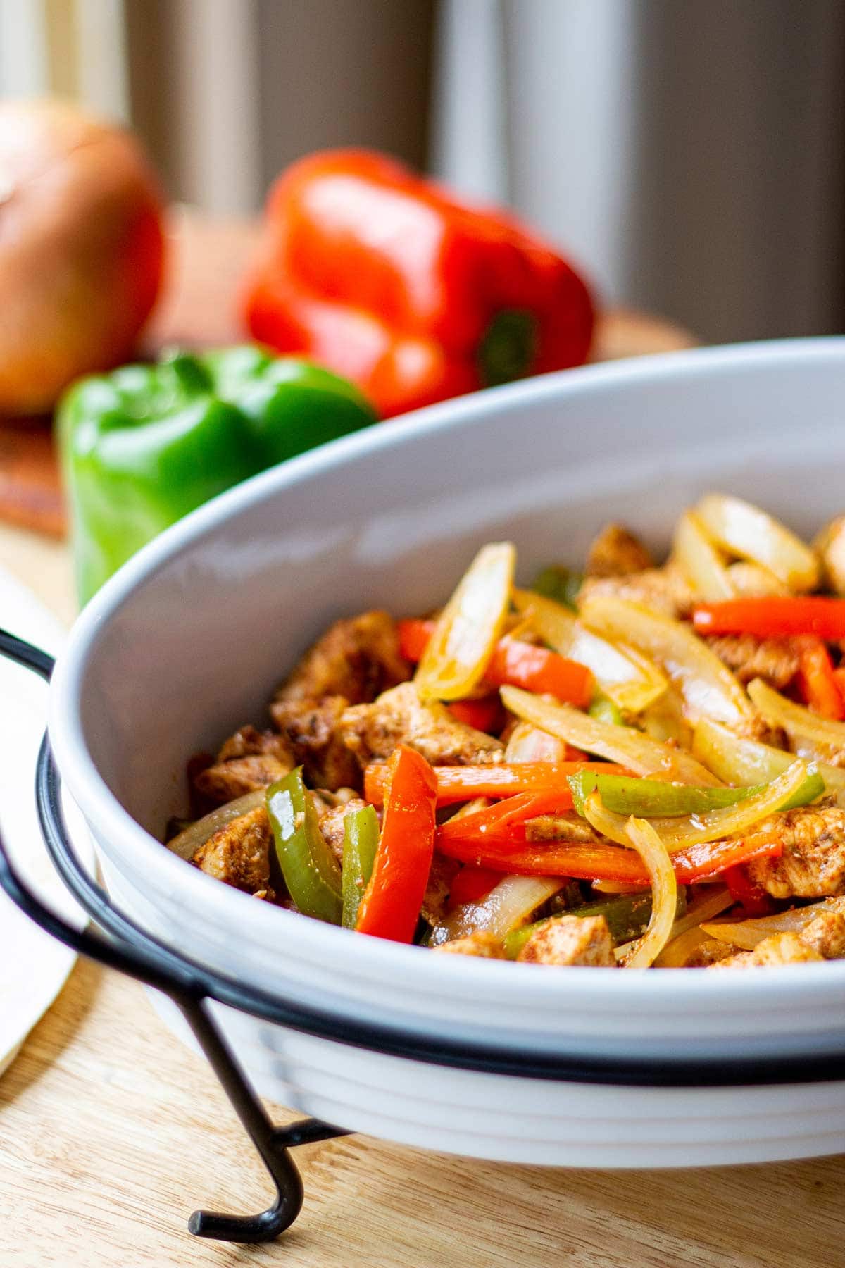 freezer fajitas with chicken, peppers and onions, cooked in serving bowl on table.