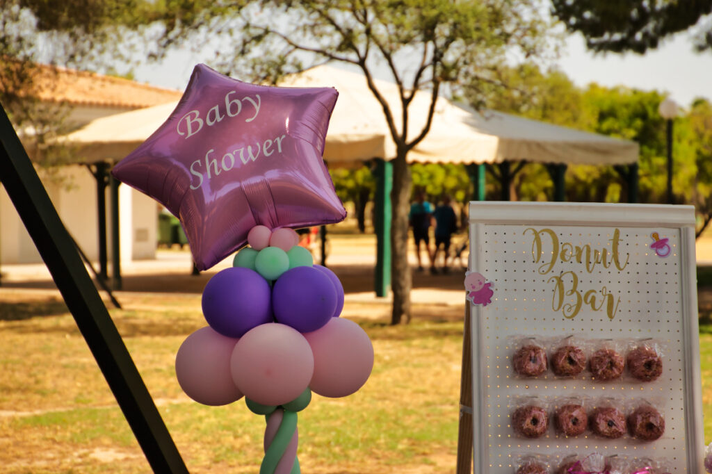 pink balloon with the words "baby shower" and donut bar.