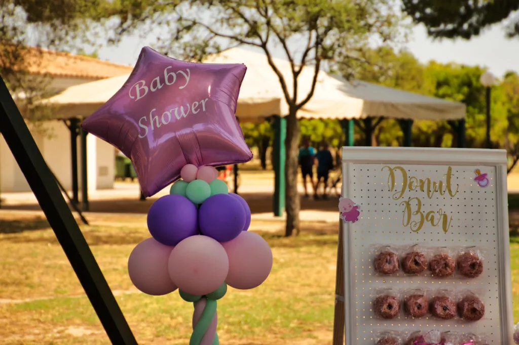 pink balloon with the words "baby shower" and donut bar.
