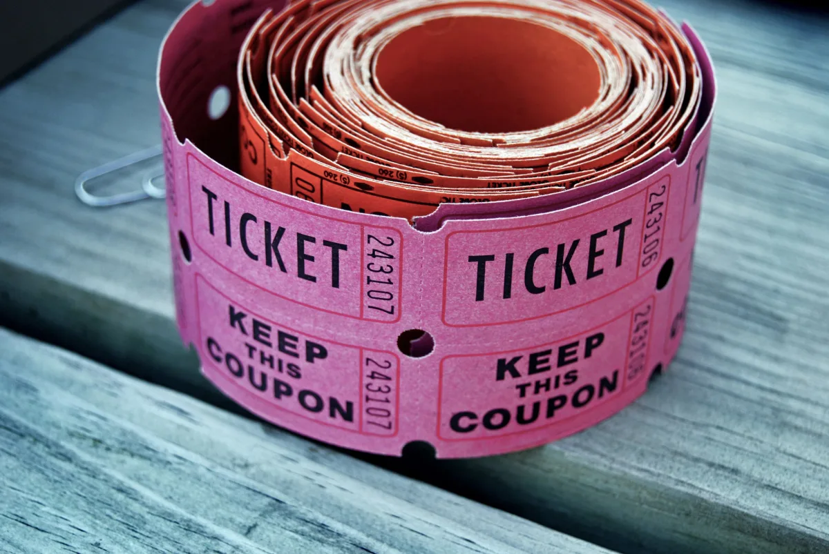 roll of pink raffle tickets for baby shower on picnic table.