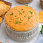 cottage cheese queso dip in large white ramekin with tortilla chips nearby.