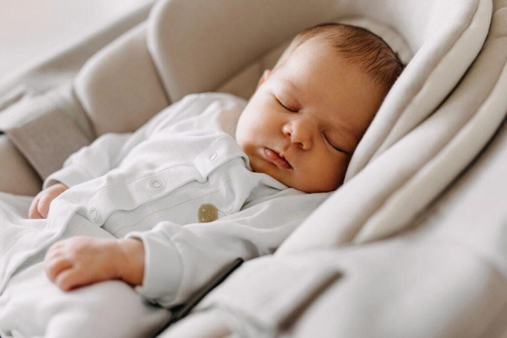 baby taking a nap in a swing.