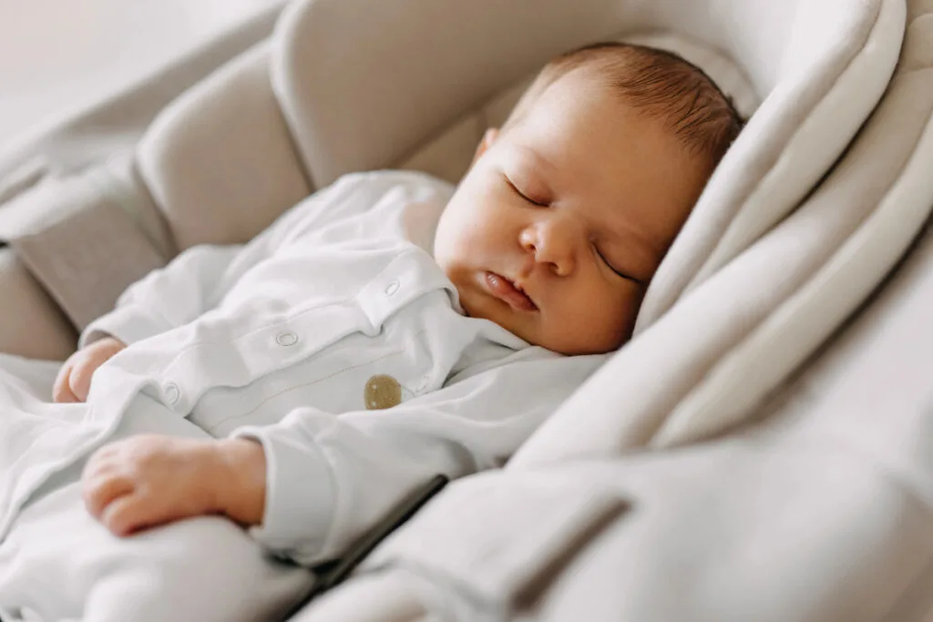 baby taking a nap in a swing.