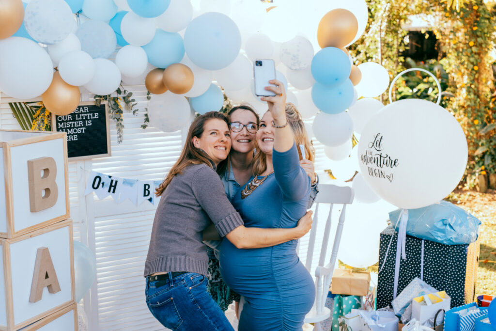 thankful pregnant woman taking selfie with baby shower hostesses