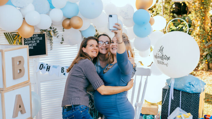 thankful pregnant woman taking selfie with baby shower hostesses